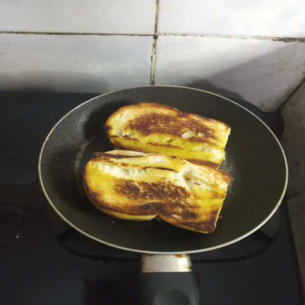 Balik roti dan olesi sisinya dengan margarin. Panggang hingga merata.