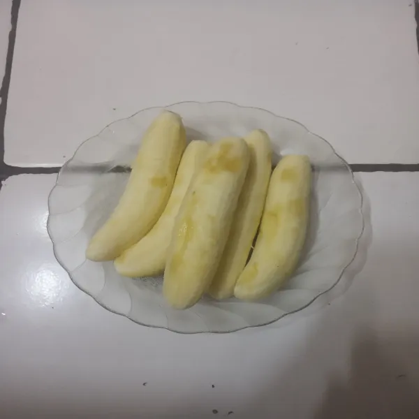 Belah pisang menjadi dua bagian.