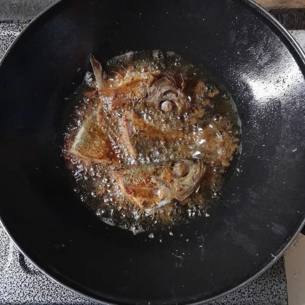 Tuang sisa bumbu marinasi ke dalam minyak, goreng hingga ikan garing, sajikan dengan sambal.