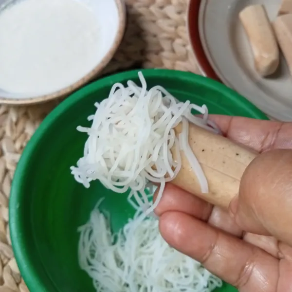 Ambil sepotong sosis dan gulung dengan bihun pada bagian yang tidak dikerat.