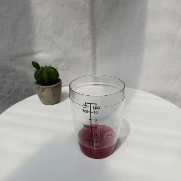 Tuang sari buah anggur dalam gelas shaker.