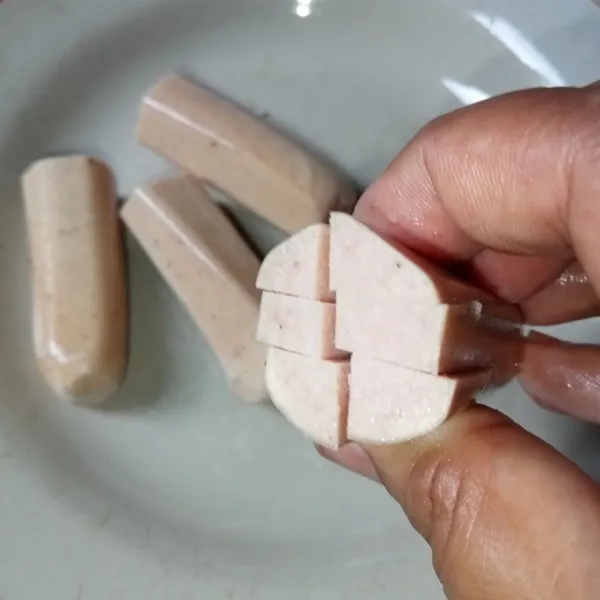 Potong dua sosis, kerat salah satu ujung sosis.