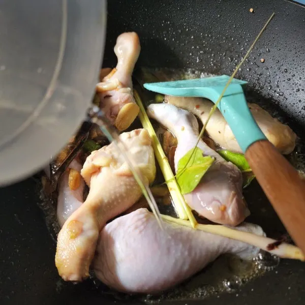 Masukkan ayam, lalu tambahkan air. Tutup panci. Masak hingga ayam matang dan air menyusut.