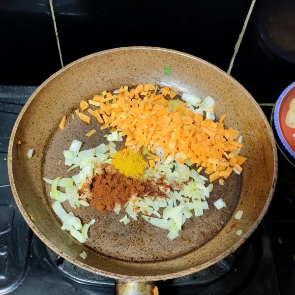 Tambahkan wortel, bubuk kari, paprika bubuk aduk rata.