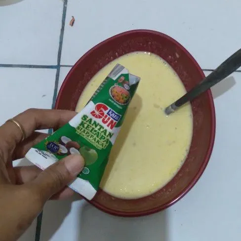 Tambahkan santan instan, lalu aduk rata lagi. Pastikan adonan cenderung encer.