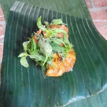 Siapkan daun pisang, ambil potongan ayam secukupnya, beri daun kemangi sesuai selera.