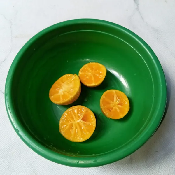Belah jeruk kasturi dan buang bijinya.
