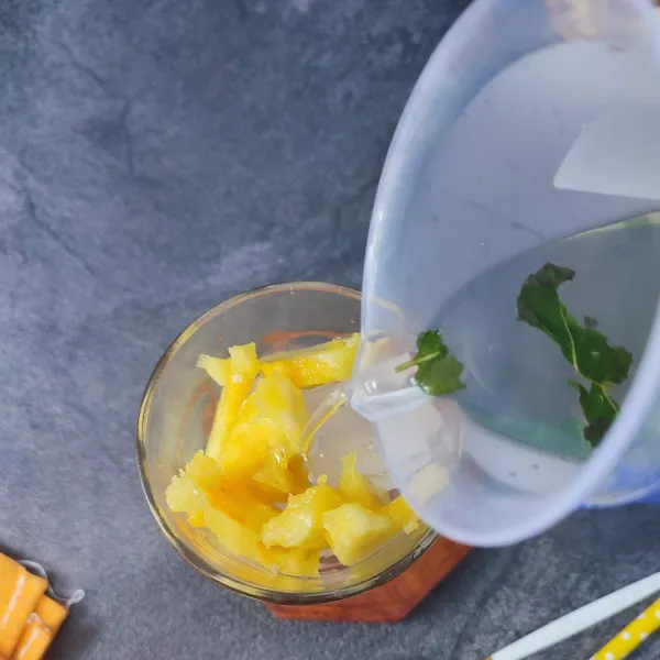 Tambahkan potongan nanas dan tuang dengan air campuran daun mint. 
Sajikan.