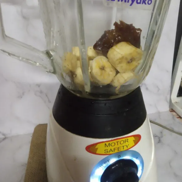 Masukkan pisang beku dan kurma ke dalam blender.