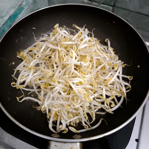 Tumis bawang putih cincang sampai harum lalu masukkan tauge, aduk rata.