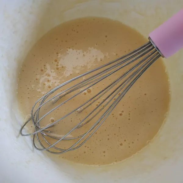 Campur gula pasir dan telur, kocok menggunakan whisk sampai gula larut.