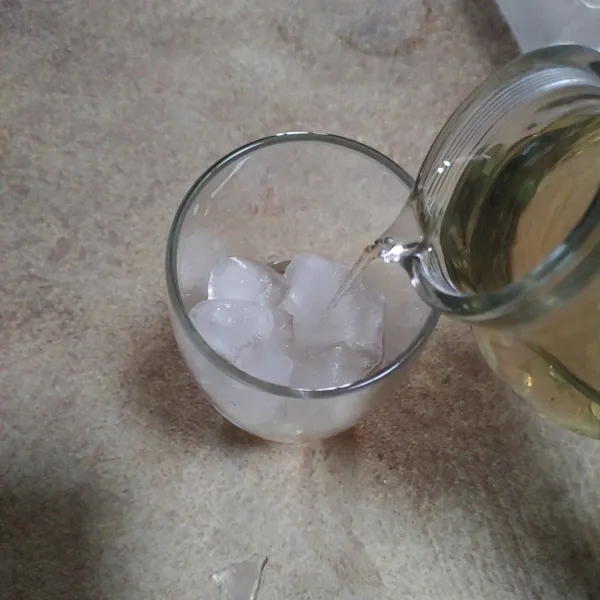 Tuang es batu dan sirup gula ke dalam gelas.