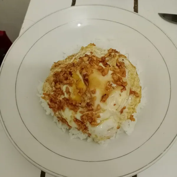 Letakkan telur di atas nasi putih hangat. Siap dinikmati