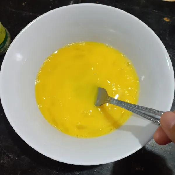 Kocok lepas telur pakai garpu.