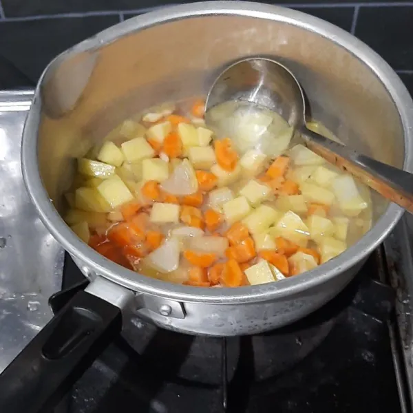 Tuang air lalu masukkan wortel dan kentang masak hingga empuk, sisihkan.