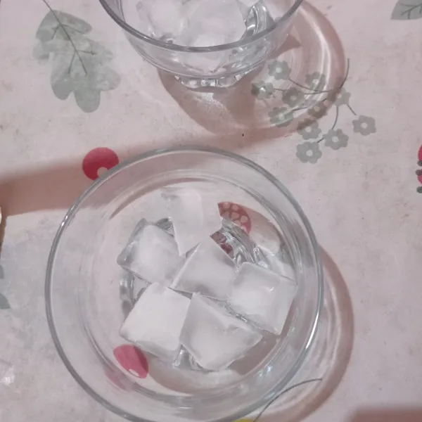 Penyajian taruh es batu dalam gelas saji