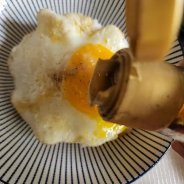 Beri telur diatasnya, lalu siram menggunakan shoyu dan minyak wijen.