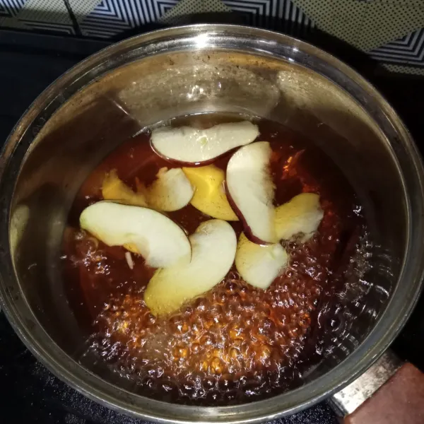 Masukkan apel yang sudah diiris tipis.