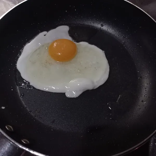 Panaskan sedikit minyak lalu goreng telur setengah matang.