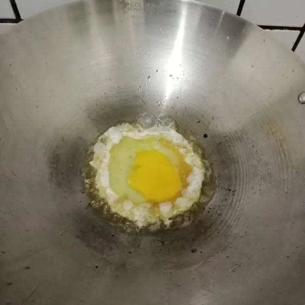 Panaskan minyak agak banyak untuk goreng telur. Ceplok telur di wajan.