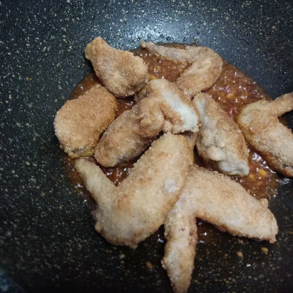 Masukan ayam yang telah digoreng aduk rata masukan daun bawang dan wijen angkat sajikan