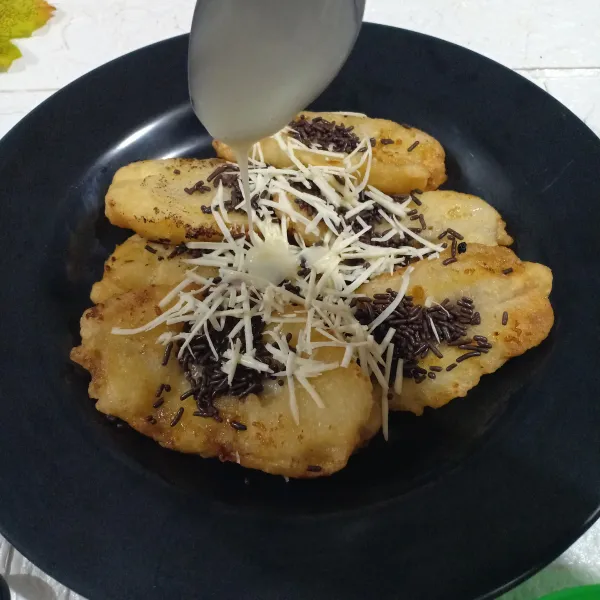 Sajikan pisang geprek dengan taburan keju, ceres dan kental manis.