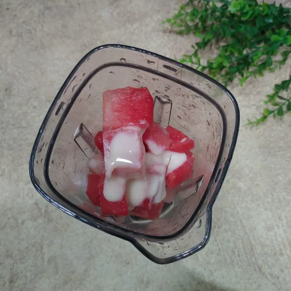 Masukkan semangka dan kental manis ke dalam blender.