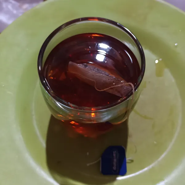 Seduh teh celup dengan air panas sampai berwarna. Lalu buang kantongnya.