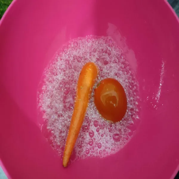 Cuci bersih wortel dan tomat dengan cairan pencuci buah dan sayur, kemudian potong-potong.