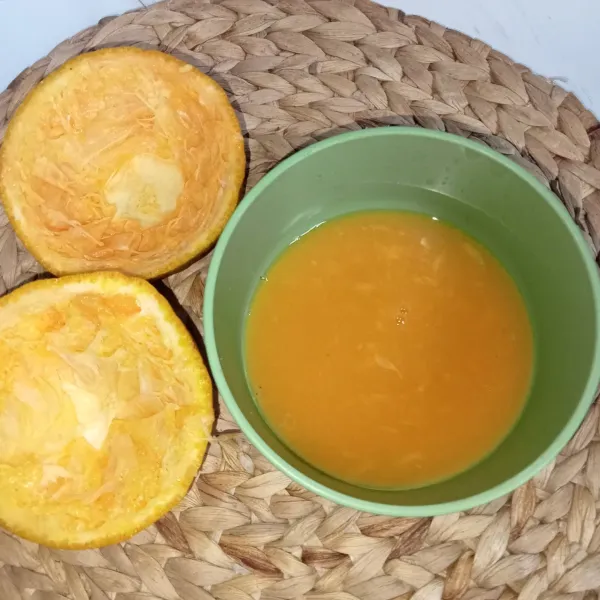 Belah dua jeruk dan peras ambil airnya.