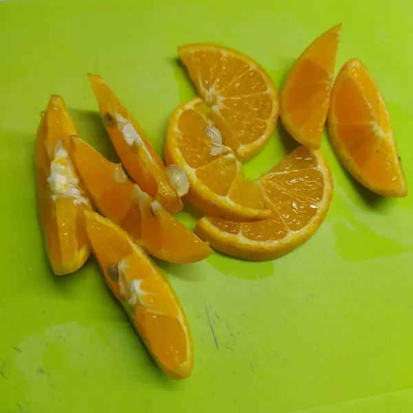 Cuci bersih jeruk di air mengalir, lalu iris-iris jeruk sesuai selera.