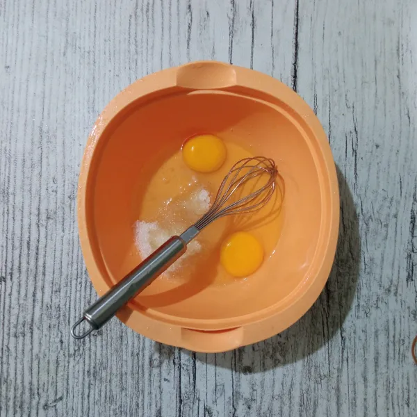 Masukkan telur dan gula pasir, kocok sampai gula larut.