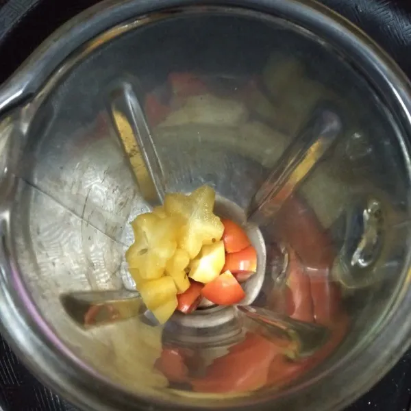 Cuci bersih buah tomat dan belimbing, potong-potong dan buang bijinya.