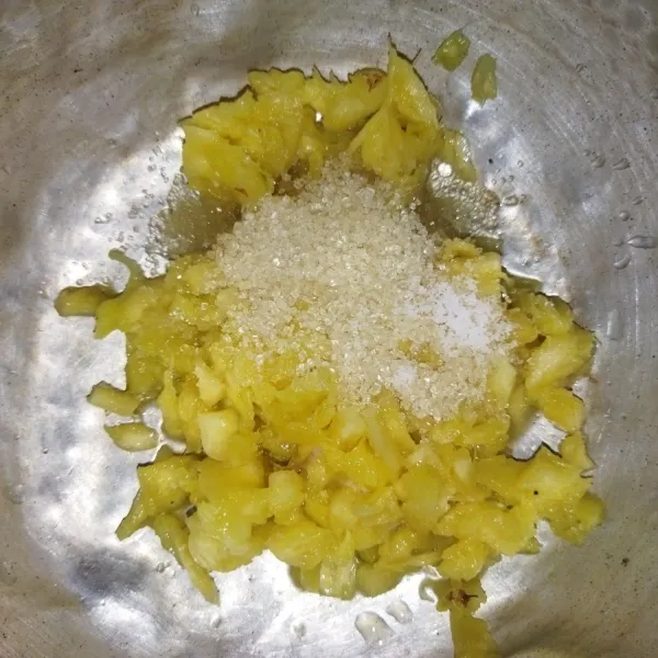 Masukkan nanas yang sudah dicacah ke dalam panci, tambahkan gula pasir.