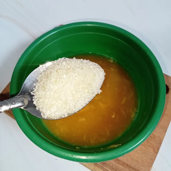 Tambahkan gula pasir pada air jeruk, aduk-aduk hingga gula larut.