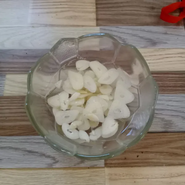 Rendam bawang putih iris dengan air yang diberi sedikit garam. Kemudian tiriskan.
