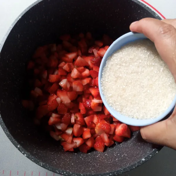 Masukkan strawberry ke panci anti lengket. Tambahkan gula pasir, garam dan jus lemon. Aduk rata.