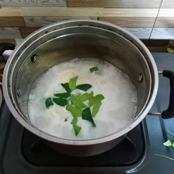 Didihkan air lalu masukkan santan instan, daun jeruk dan bawang putih geprek.