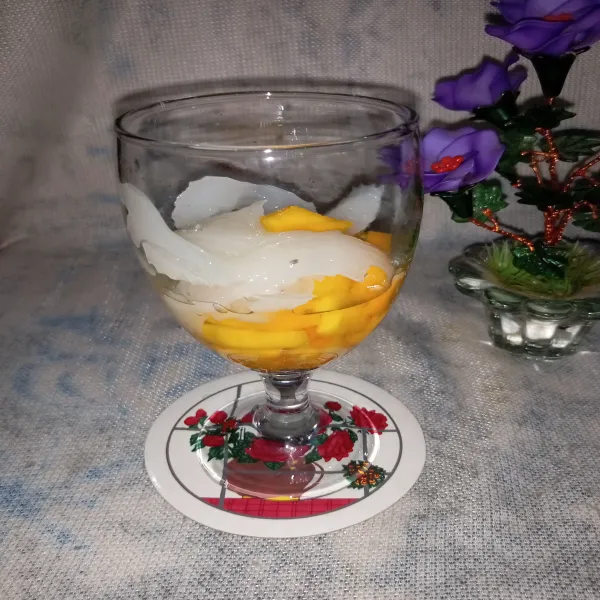 Masukkan kelapa dan potongan mangga ke dalam gelas.