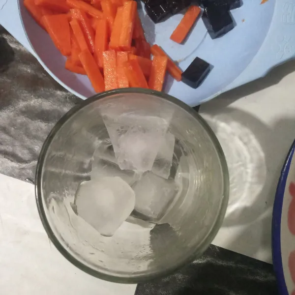 Lalu masukkan es batu ke dalam gelas saji.