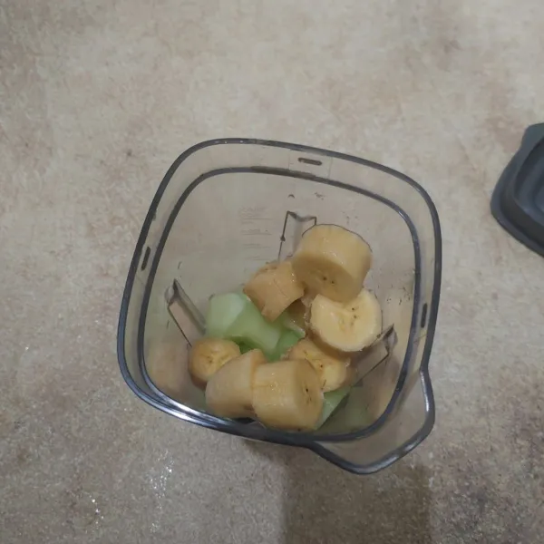Masukkan potongan buah melon dan pisang ke dalam blender.