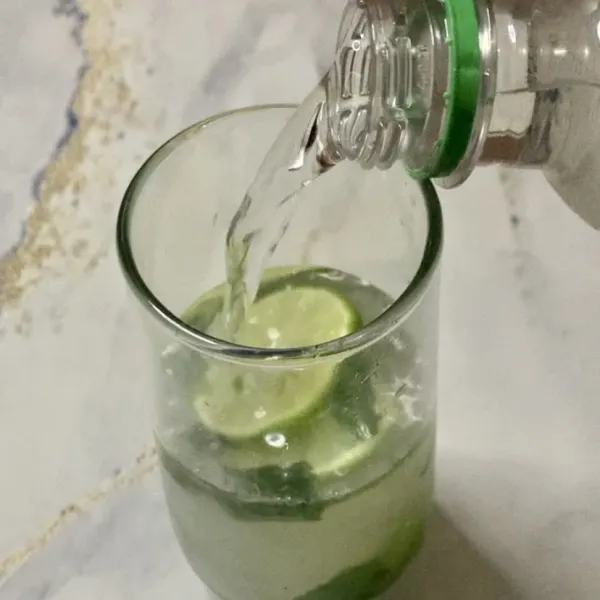 Tuang air soda & beri garnish daun mint.