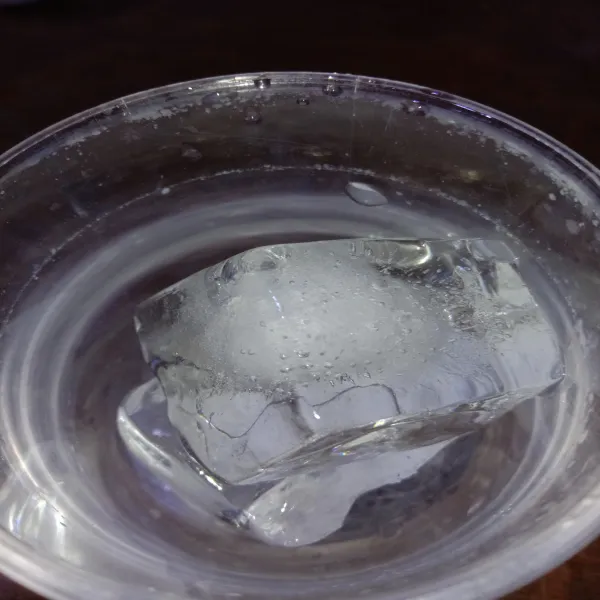 Masukkan es batu ke dalam gelas, sajikan.
