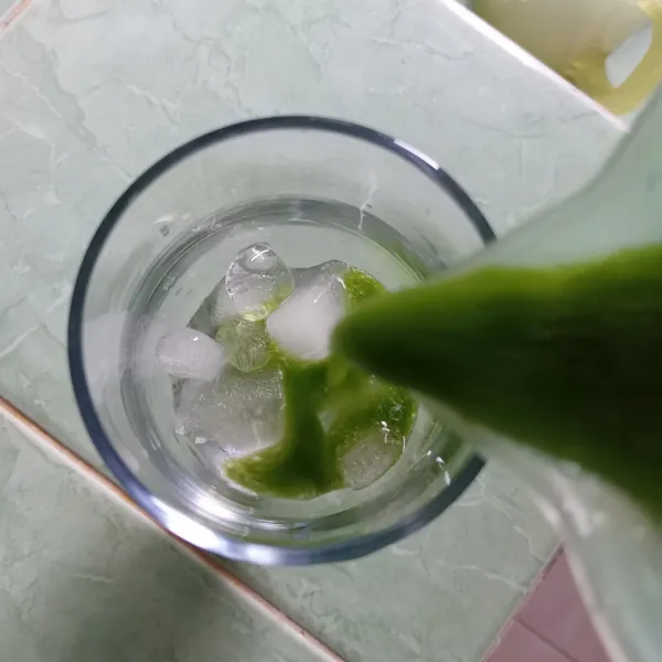 Tuang green juice dalam gelas yang telah diberi es batu dan sajikan.