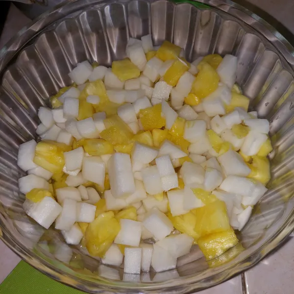 Potong bengkuang dan nanas lalu taruh dalam wadah.