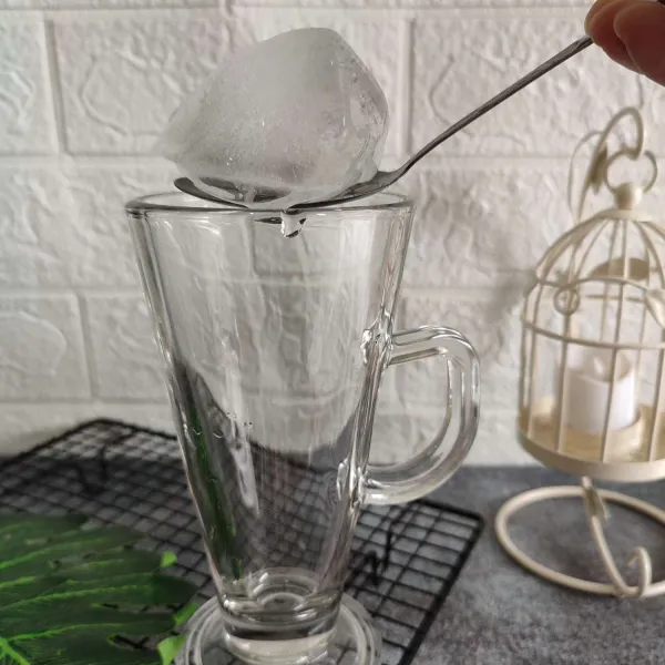 Masukkan es batu ke dalam gelas saji.