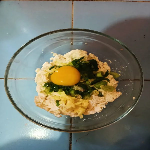 Tambahkan telur, daun bawang dan bawang putih halus.