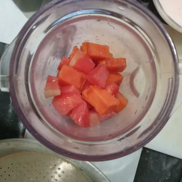 Masukkan potongan buah ke dalam blender.