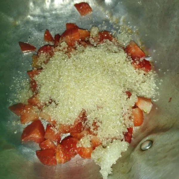 Siapkan strawberry yang sudah dipotong-potong, lalu masukkan ke dalam panci, lalu tambahkan gula pasir.