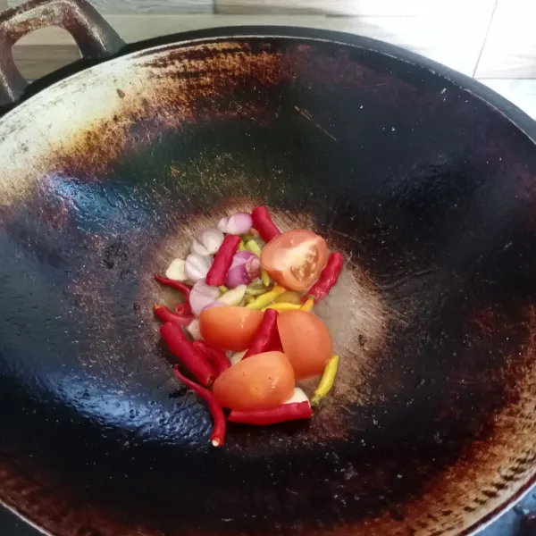 Goreng bawang merah, bawang putih, cabe rawit, cabe merah keriting dan tomat sampai matang.